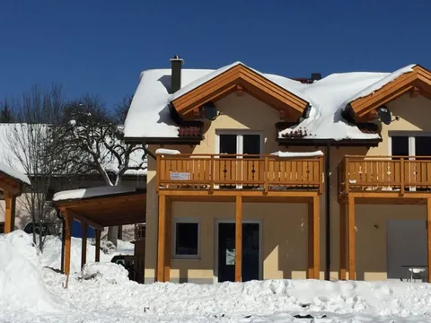 Zijaanzicht van het huis met balkon in de sneeuw