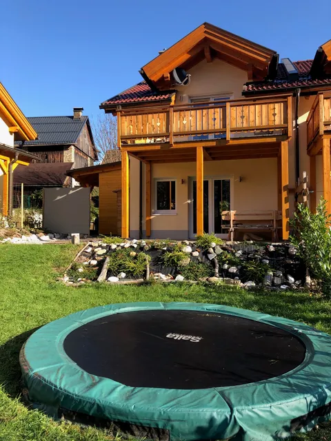 Achterkant van het huis op een zonnige dag met trampoline