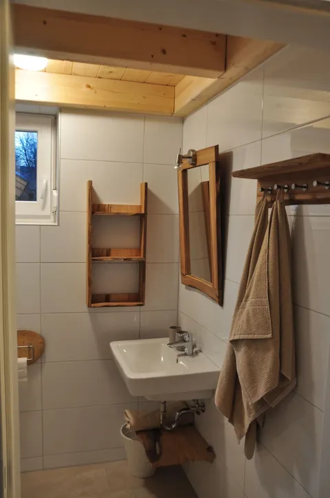Wastafel met houten spiegel in de tweede badkamer