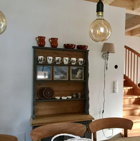 Houten dressoir met servies en foto's, trap op de achtergrond