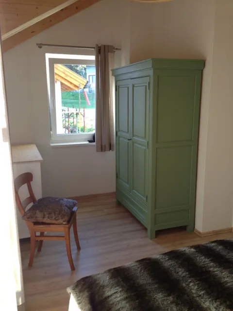 Tweepersoonsbed met houten wandpaneel in slaapkamer 1
