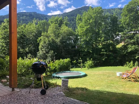 Achtertuin met trampoline en uitzicht op de bergen