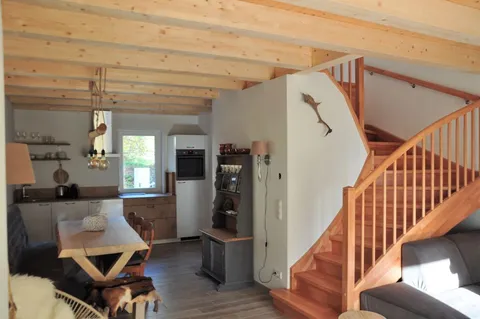Woonkamer met trap en eethoek in beeld
